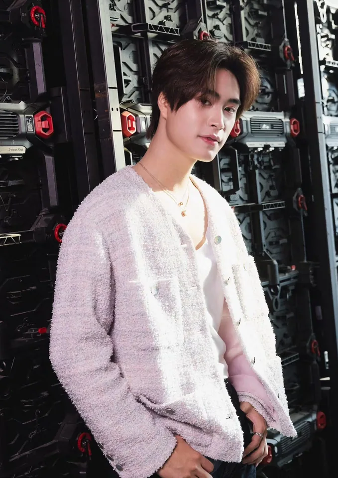 เจมีไนน์ นรวิชญ์ ยืนในแจ็กเก็ตสีขาวหน้าฉากสีดำ